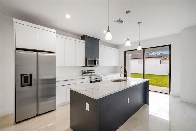kitchen with a sink, appliances with stainless steel finishes, an island with sink, modern cabinets, and decorative light fixtures