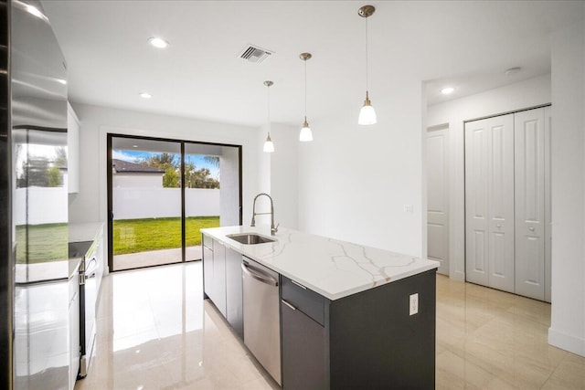 kitchen with decorative light fixtures, visible vents, appliances with stainless steel finishes, a kitchen island with sink, and a sink