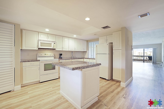 kitchen featuring white appliances, visible vents, light wood-type flooring, white cabinetry, and backsplash