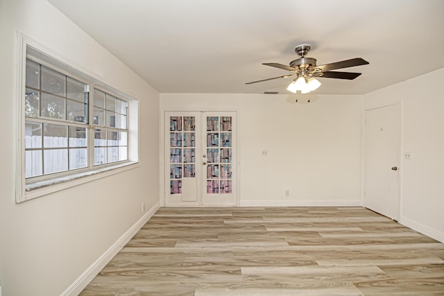 spare room featuring ceiling fan, light hardwood / wood-style floors, and french doors