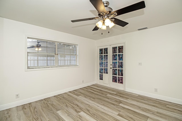 empty room with light hardwood / wood-style floors, french doors, and ceiling fan