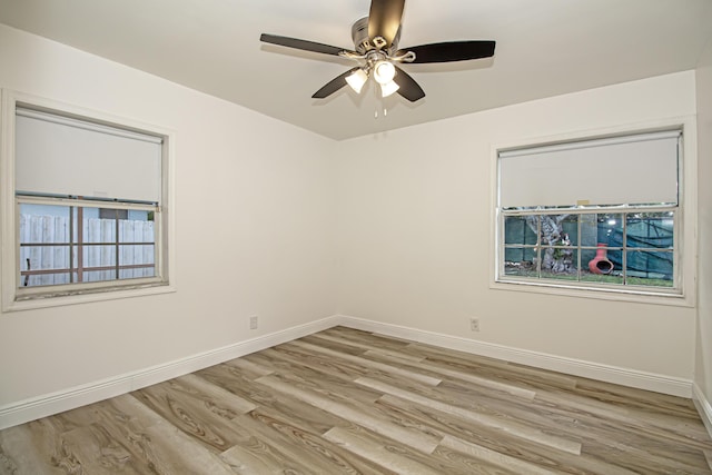 empty room featuring ceiling fan, a healthy amount of sunlight, and light hardwood / wood-style flooring