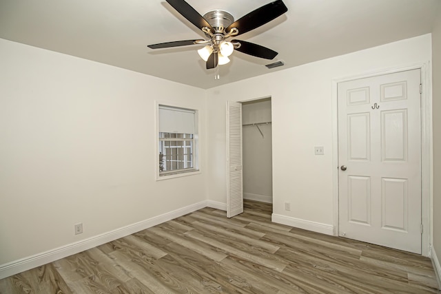 unfurnished bedroom featuring ceiling fan, a closet, and light wood-type flooring