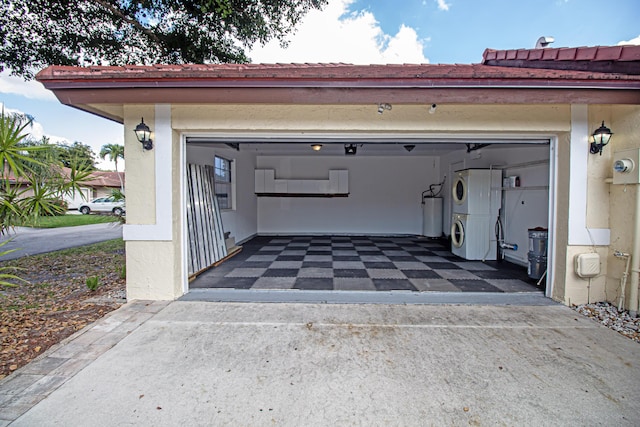 garage featuring stacked washer / dryer