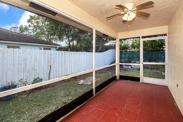 unfurnished sunroom with ceiling fan