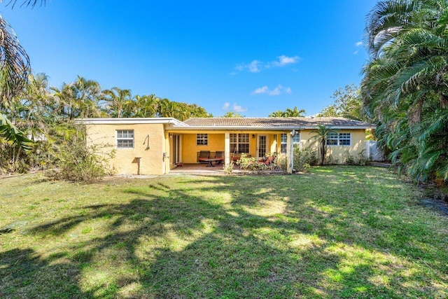 back of house with a yard and a patio area