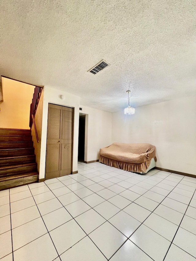 unfurnished bedroom with light tile patterned floors, baseboards, visible vents, and a textured ceiling