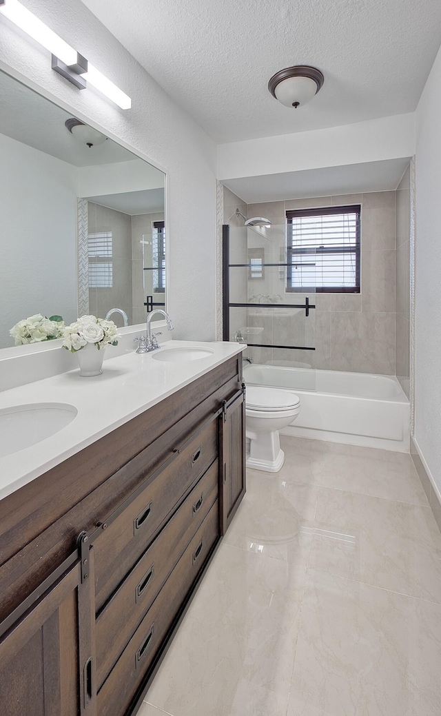 bathroom featuring double vanity, toilet, a sink, a textured ceiling, and  shower combination