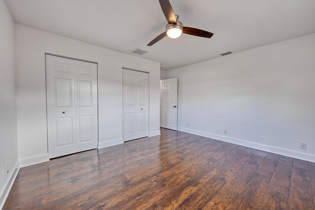 empty room with ceiling fan, dark wood-style flooring, and baseboards