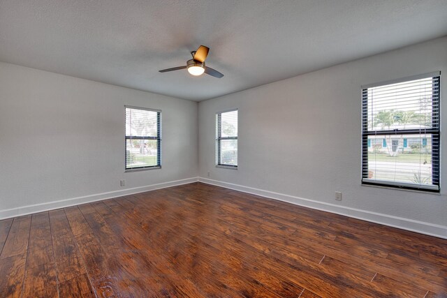 unfurnished bedroom with baseboards, visible vents, dark wood-type flooring, and two closets