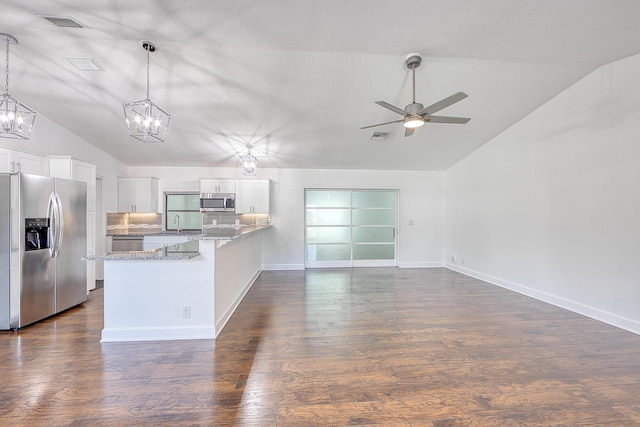 kitchen with lofted ceiling, stainless steel appliances, a peninsula, white cabinets, and dark wood finished floors