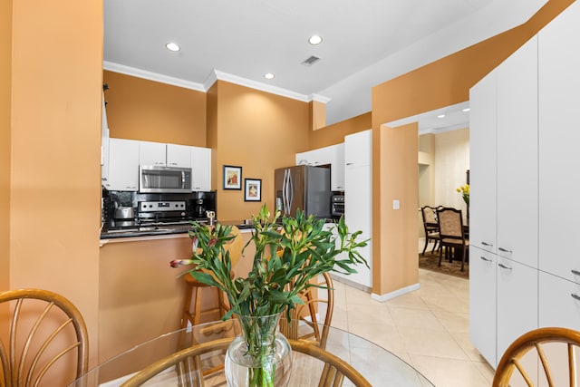 dining room featuring light tile patterned floors and crown molding