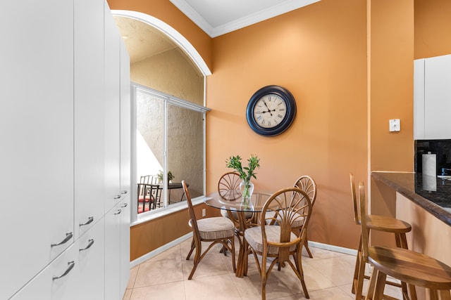 tiled dining space featuring ornamental molding