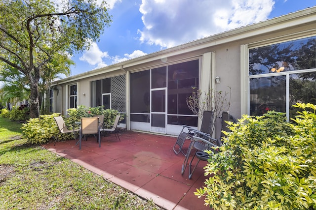 back of property featuring a sunroom and a patio area