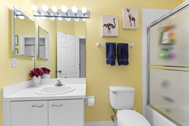 full bathroom featuring vanity, shower / bath combination with glass door, and toilet