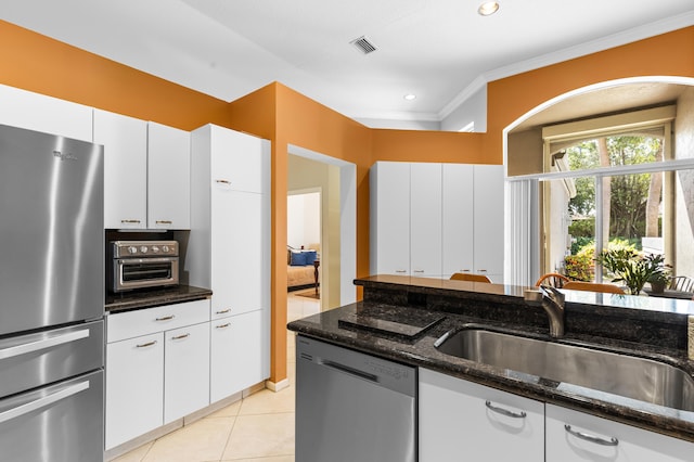 kitchen featuring white cabinetry, stainless steel appliances, sink, and dark stone counters