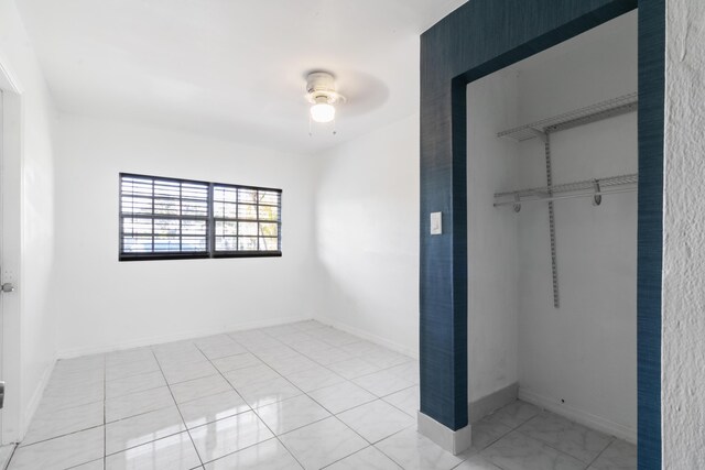 unfurnished bedroom featuring baseboards, a ceiling fan, and a closet