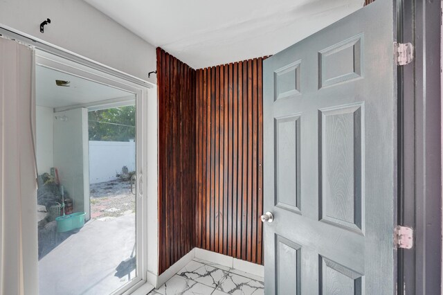 doorway to outside with marble finish floor