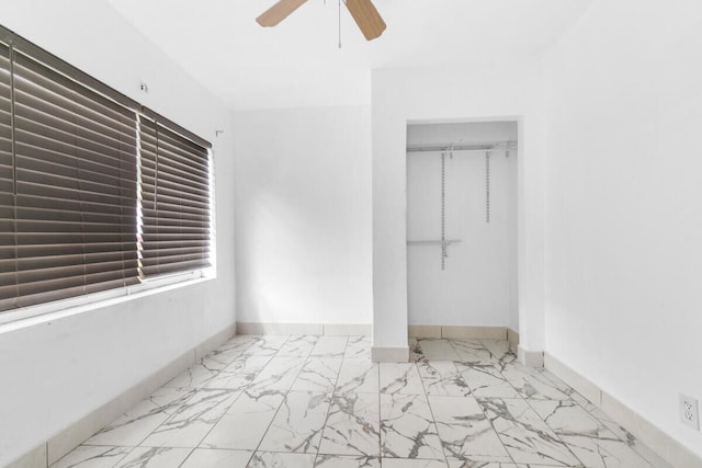 unfurnished bedroom with baseboards, ceiling fan, a closet, and marble finish floor