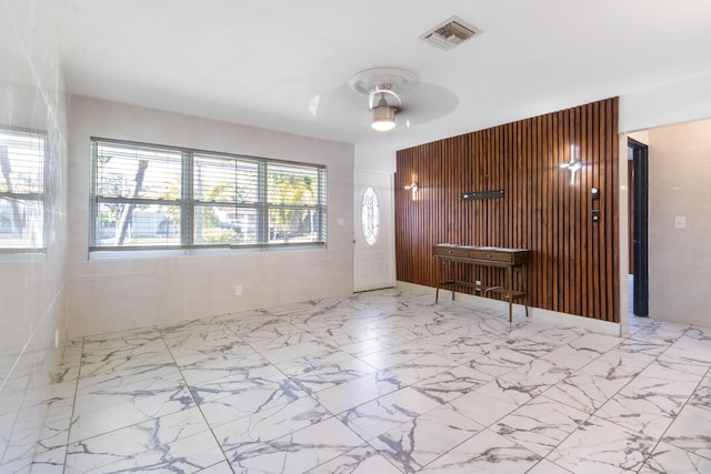 foyer entrance with visible vents, marble finish floor, and ceiling fan