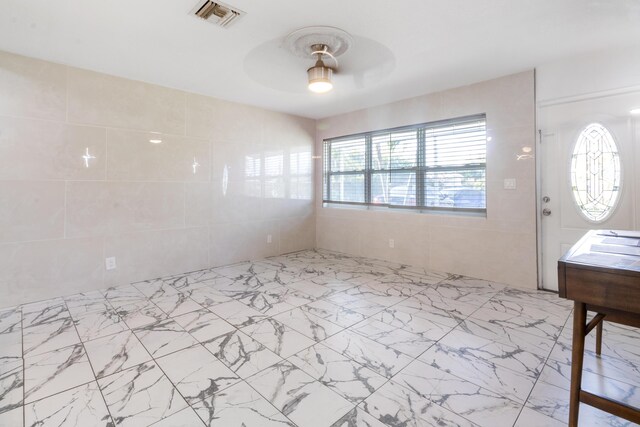 living area with ceiling fan, marble finish floor, and visible vents