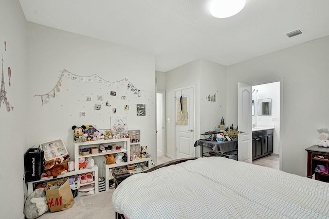 bedroom with light carpet and ensuite bathroom