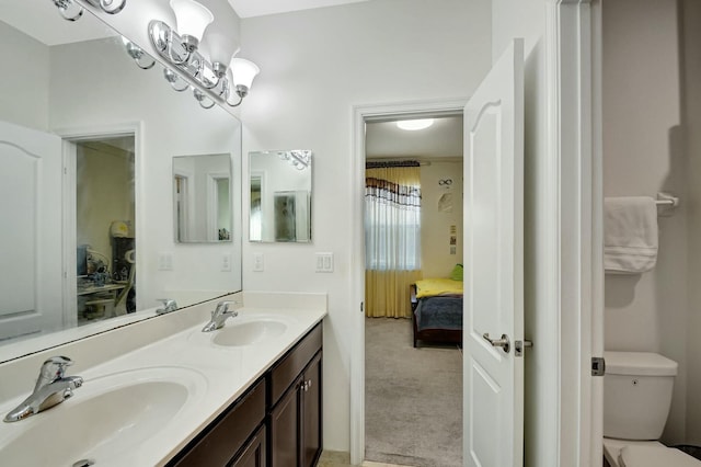 bathroom with vanity, a chandelier, and toilet