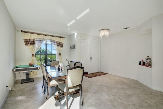 tiled dining room featuring an inviting chandelier