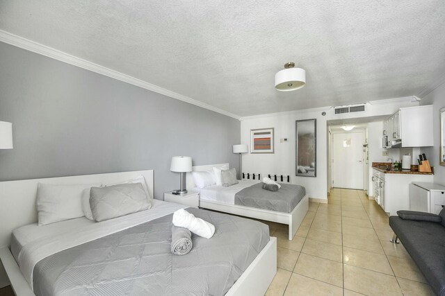 bedroom with crown molding, a textured ceiling, and light tile patterned floors