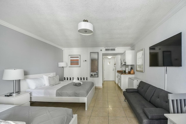 bedroom featuring light tile patterned floors, ornamental molding, and a textured ceiling