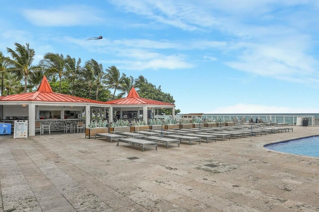 view of home's community featuring a gazebo, a swimming pool, a patio, a water view, and exterior bar