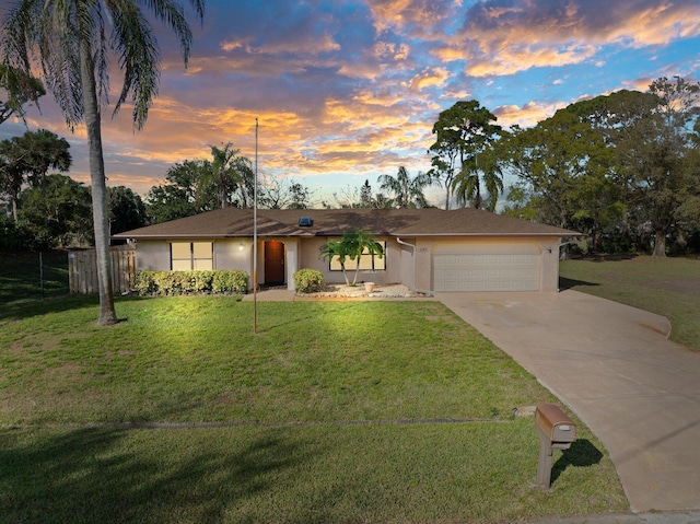 single story home with a garage and a lawn