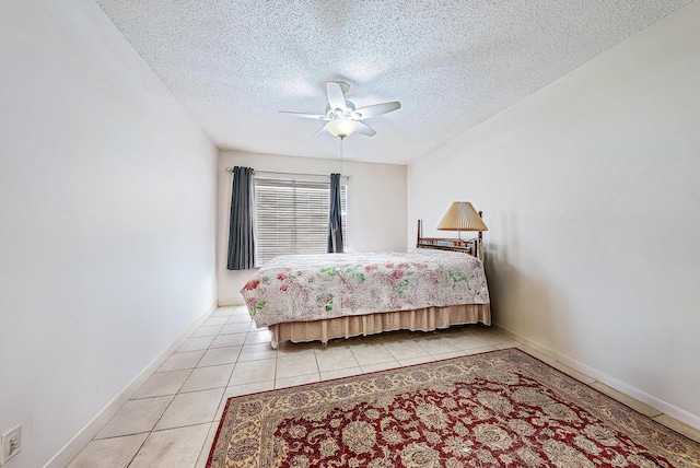 tiled bedroom featuring ceiling fan and a textured ceiling