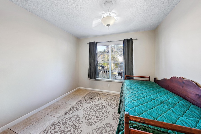 bedroom featuring light tile patterned flooring, ceiling fan, and a textured ceiling