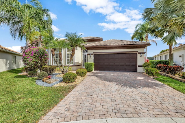 mediterranean / spanish home with a garage and a front lawn