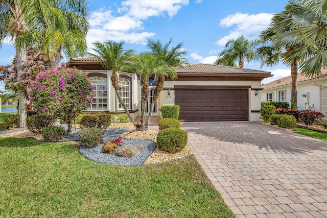 mediterranean / spanish home featuring a garage and a front lawn