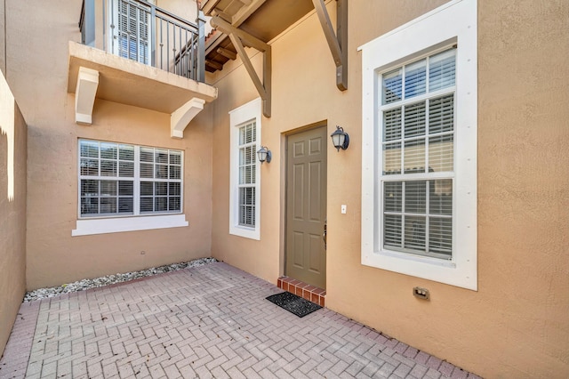 view of exterior entry with a patio