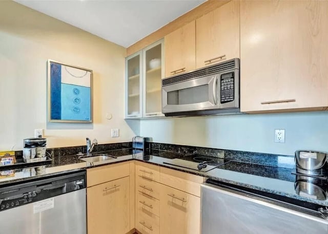 kitchen with light brown cabinetry, sink, stainless steel appliances, and dark stone counters