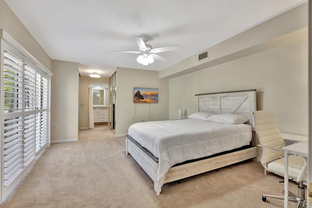 carpeted bedroom featuring ceiling fan and ensuite bath