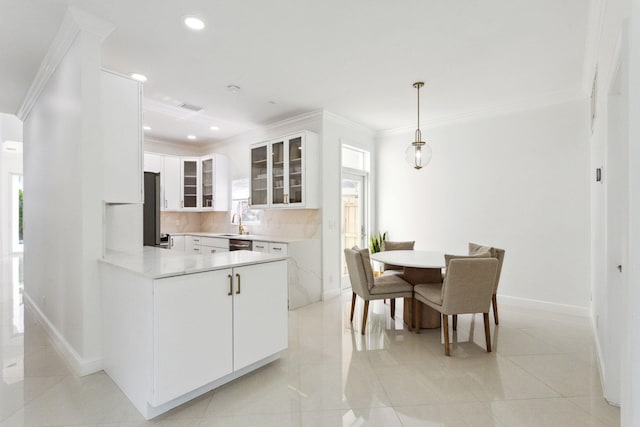 kitchen with crown molding, kitchen peninsula, white cabinets, pendant lighting, and backsplash