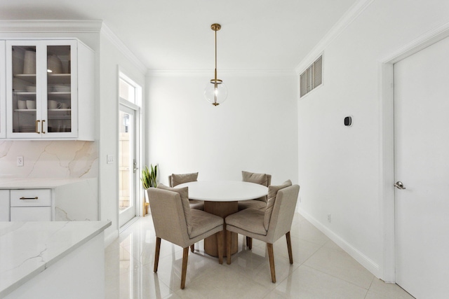 dining area with crown molding and light tile patterned floors