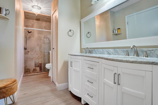 full bath featuring a stall shower, a sink, and wood finished floors