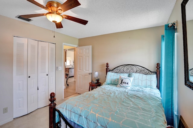 bedroom with a textured ceiling, a closet, visible vents, and a ceiling fan