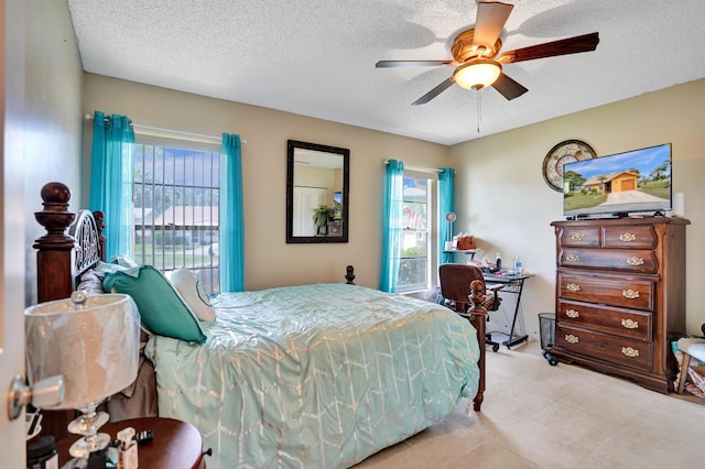 tiled bedroom featuring a ceiling fan, multiple windows, and a textured ceiling