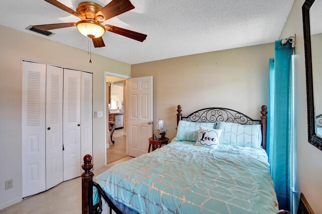 bedroom with a textured ceiling, a closet, ceiling fan, baseboards, and visible vents