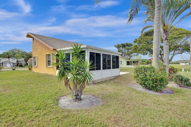 back of house with a sunroom, a yard, and stucco siding