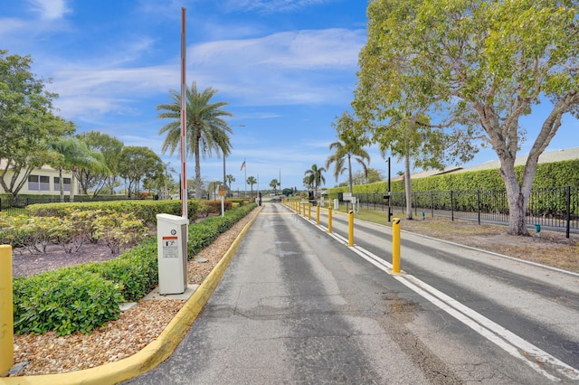 3570 Amalfi Dr, West Palm Beach, FL 33417 - view of asphalt street featuring curbs, traffic signs, and street lights