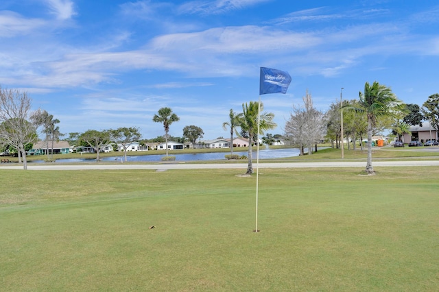 view of property's community with a lawn and a water view