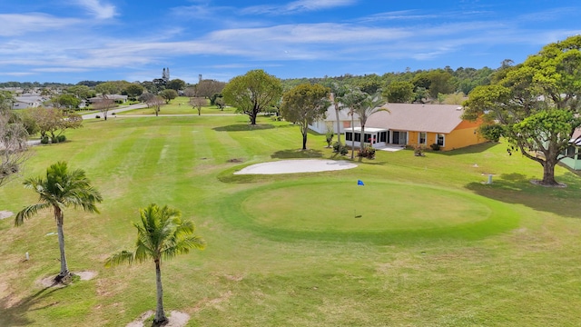 view of property's community with a lawn and view of golf course