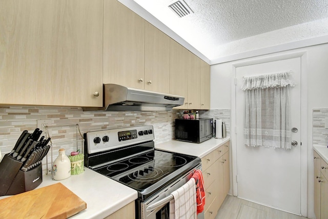 kitchen with light brown cabinetry, backsplash, electric range, and a textured ceiling